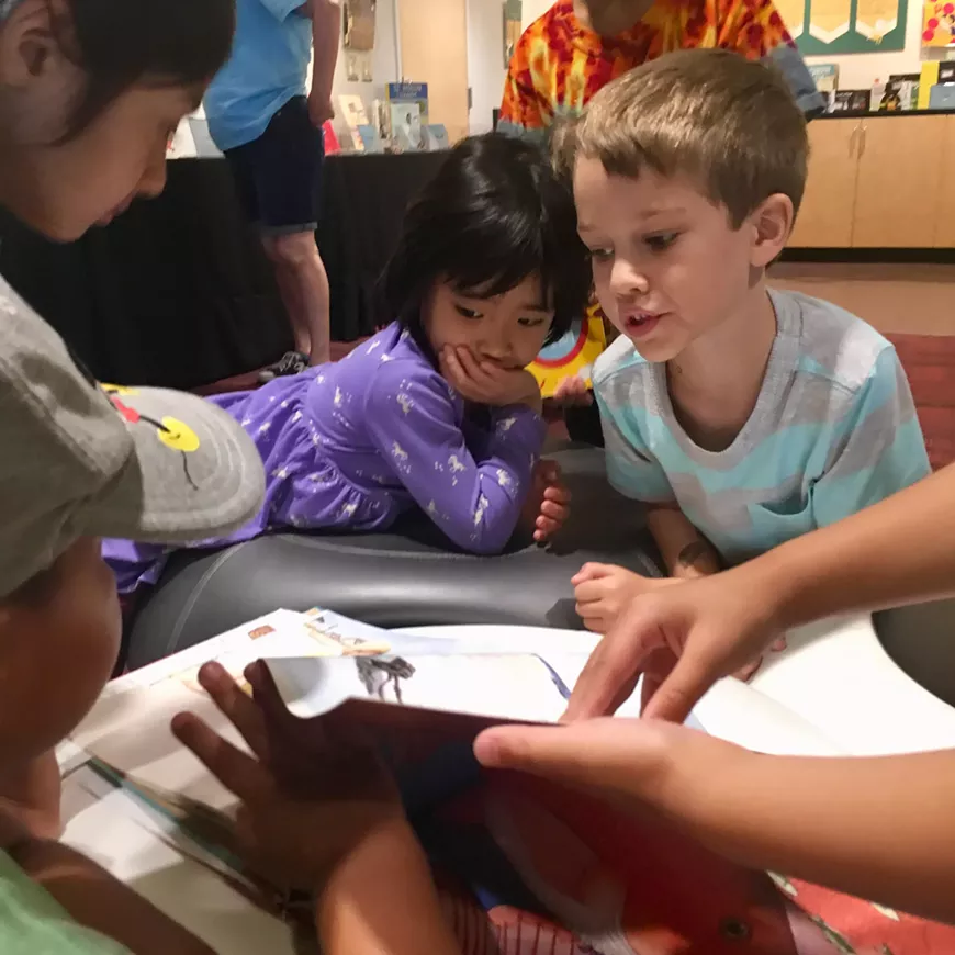 UofA Fusion campers from the kindergarten/first grade group read through David Wiesner&rsquo;s &ldquo;Flotsam,&rdquo; which takes readers on a surreal journey through an underwater world. Flotsam is one of dozens of books on display at Worlds of Words as part of their Visual Narratives exhibit.