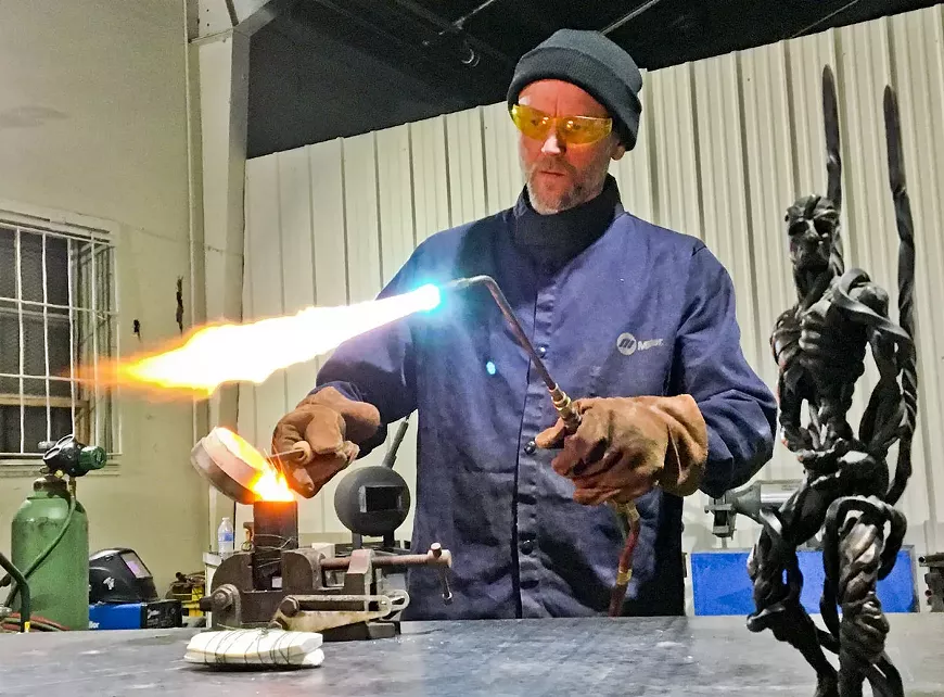 DMC casting instructor Spencer Edgerton pours molten bronze into a mold.