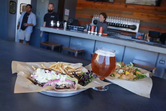 The Garage’s split fennel sausage sandwich, calamari and a Dragoon ale.