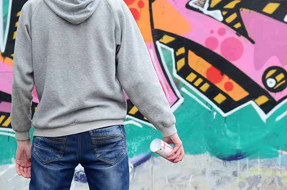 bigstock-a-young-graffiti-artist-in-a-g-246208052.webp