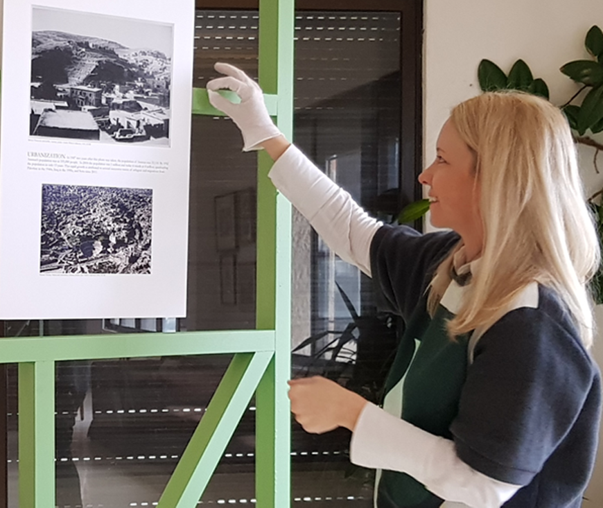 Ashley Lumb installing the pop-up exhibition 'Picturing Change: The Role of Photographs in Cultural Heritage' at the American Center for Oriental Research in Amman, Jordan in January 2020