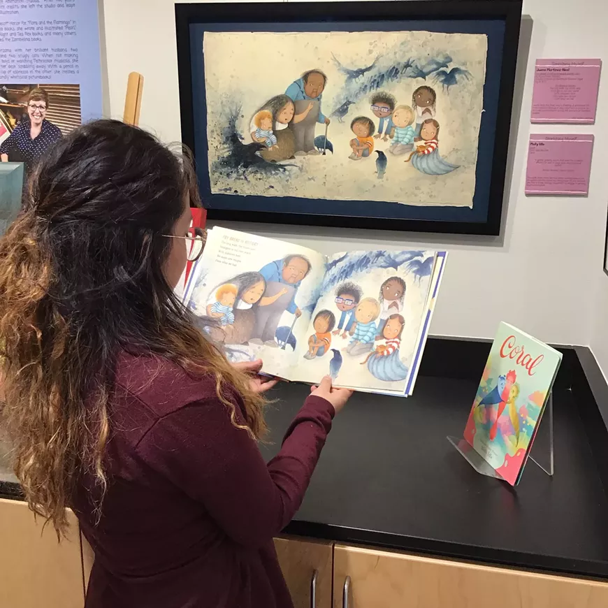 Carolina Hoyos, UArizona Family Studies and Human Development senior, contemplates an illustration from the award-winning picturebook, "Fry Bread." The illustration is a new acquisition for Worlds of Words and part of the exhibit "Critique to Support & Stretch: A Conversation between Juana Martinez-Neal & Molly Idle."